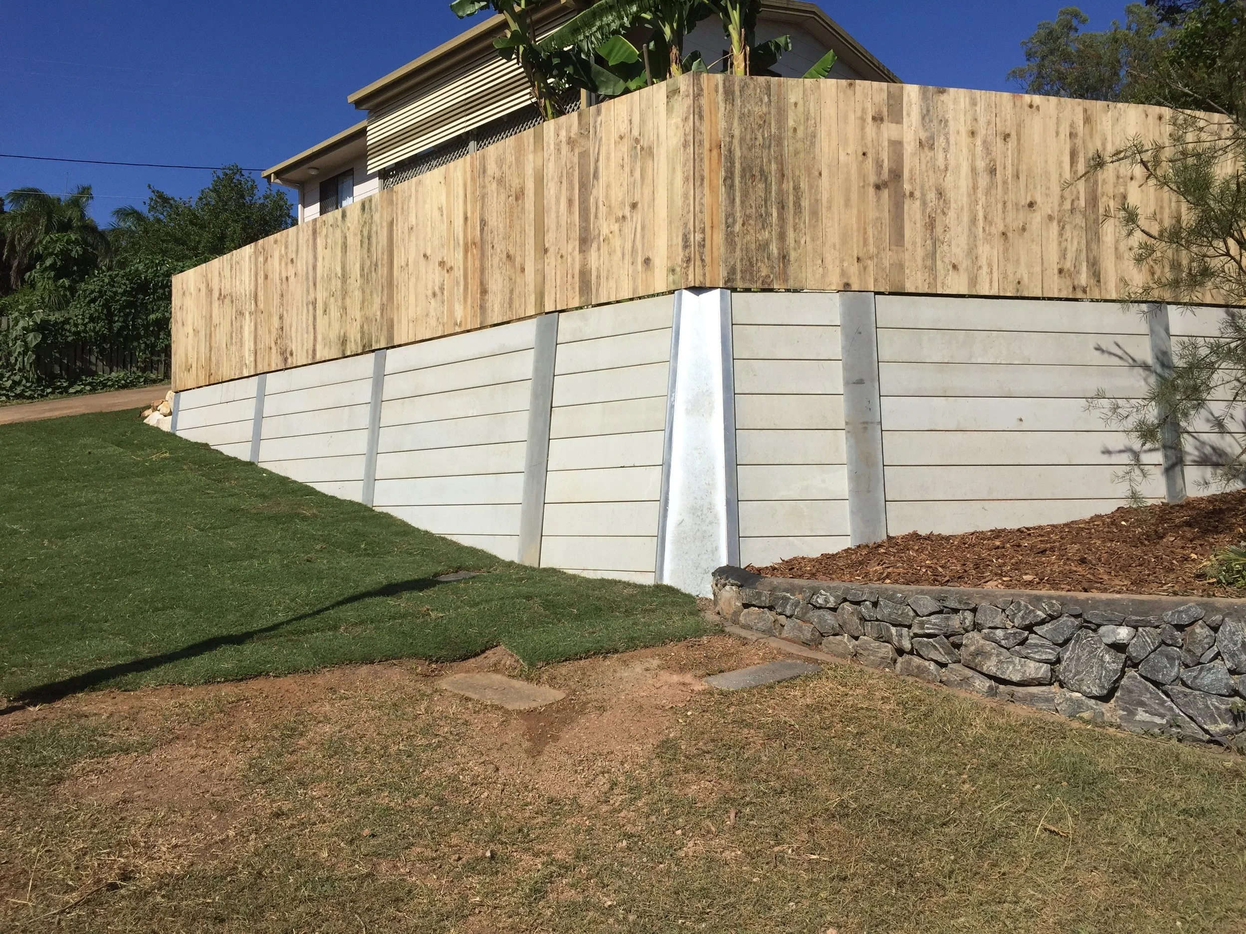 Fassifern concrete sleeper retaining wall with timber fencing